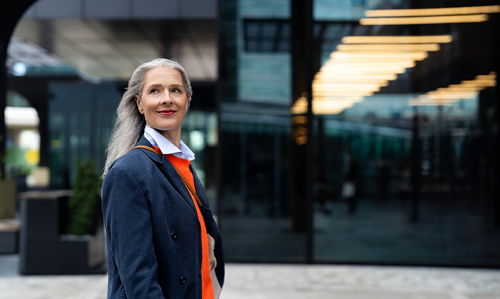 Frau mit langem Haar vor einem Bürogebäude