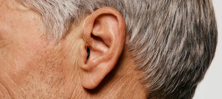 Das Bild zeigt eine Person mit Hörgerät.