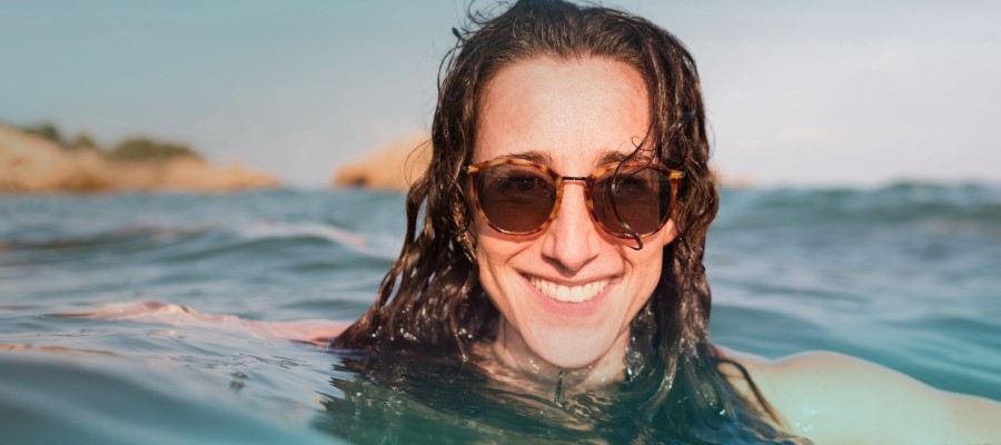 Frau mit Sonnenbrille im Wasser